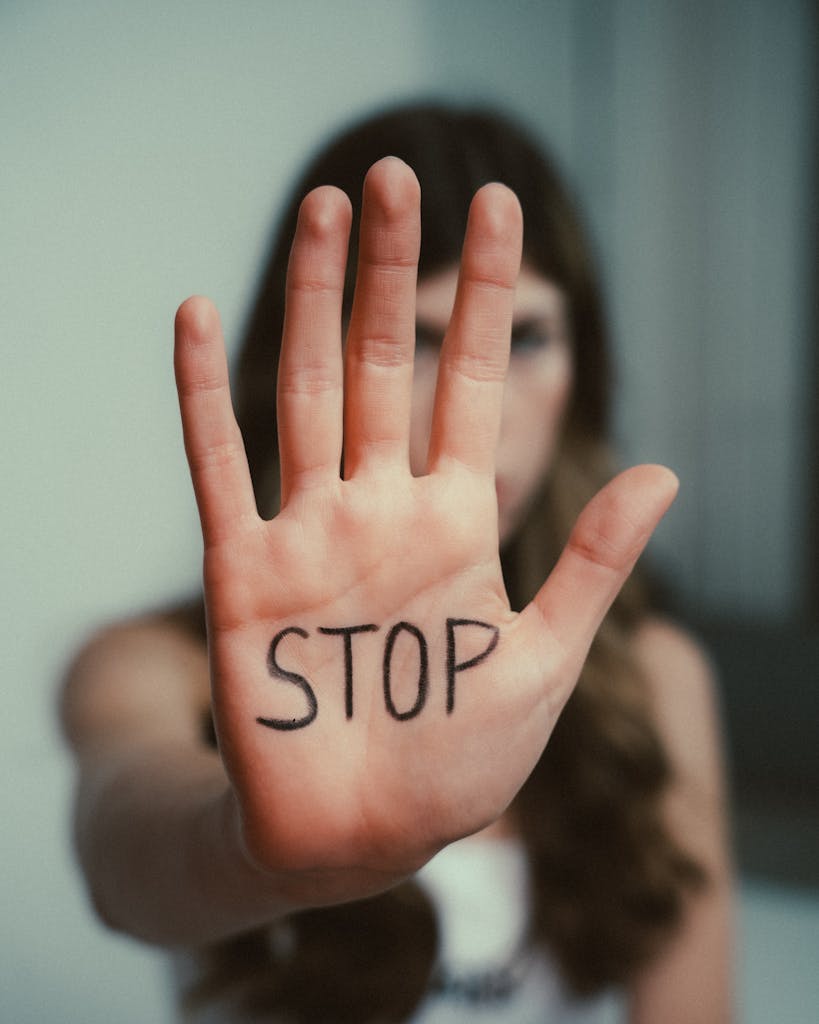 Close-up of a woman's hand with 'Stop' written on it, emphasizing awareness.